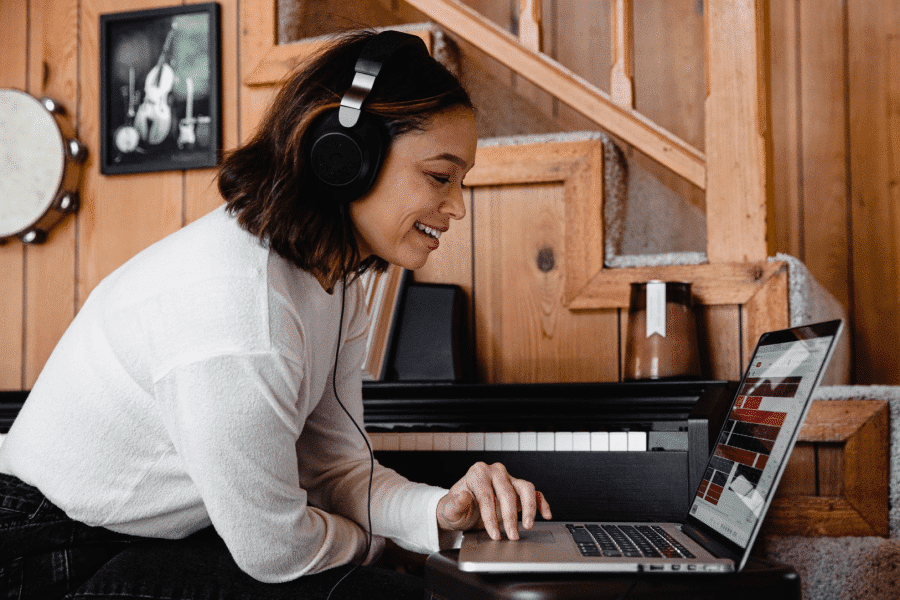 Smiling woman with headphones using laptop