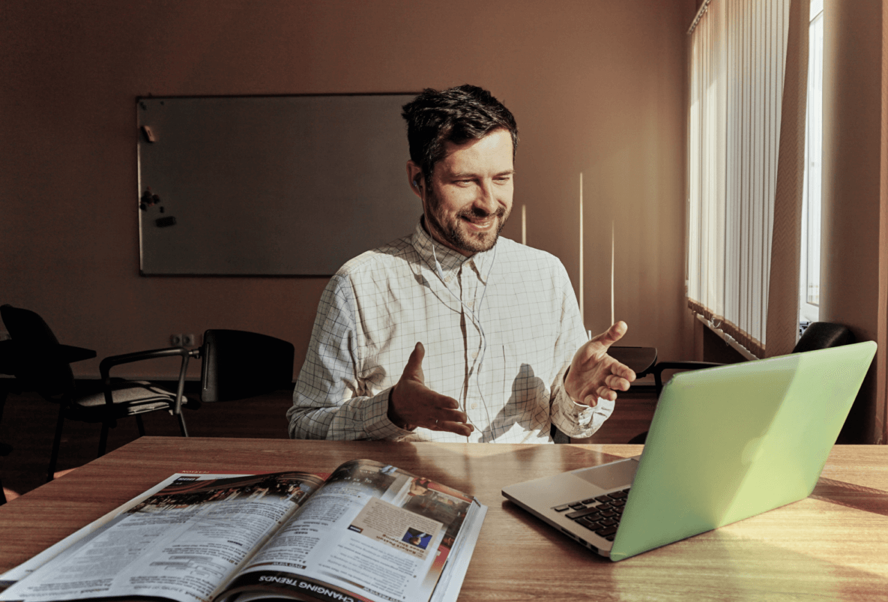 Smiling man with shirt smiles toward his laptop